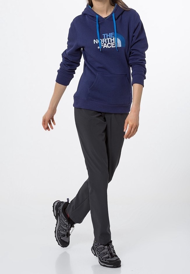 Granatowy sweatshirt z kapturem, z niebieskimi sznurkami i białym logo, zestawiony z czarnymi spodniami i czarnymi butami sportowymi. Prosty design, praktyczny krój.