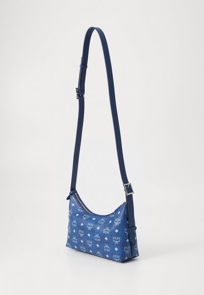 Sac à bandoulière en tissu bleu avec fermeture éclair, ornée d'un motif de logo répétitif, texture lisse et une sangle réglable.