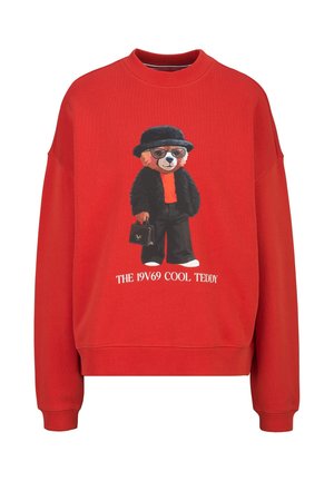 Rode trui met een teddybeer die een zonnebril, zwarte hoed en jas draagt, een handtas vasthoudt en de tekst "THE 19V69 COOL TEDDY" eronder.