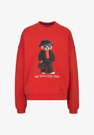 Rode trui met een teddybeer die een zonnebril, zwarte hoed en jas draagt, een handtas vasthoudt en de tekst "THE 19V69 COOL TEDDY" eronder.