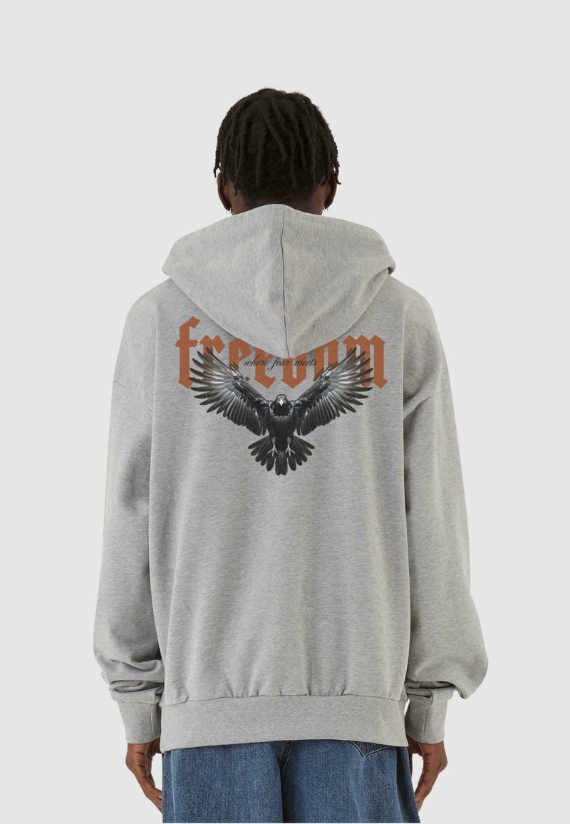 Gray hoodie with a back graphic of an eagle and the word "freedom" in orange. Features a front pocket and ribbed cuffs and hem.