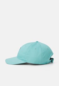 Turkos baseballkeps med en böjd skärm, tygtextur, justerbar rem bak och ventilationshål på sidorna.