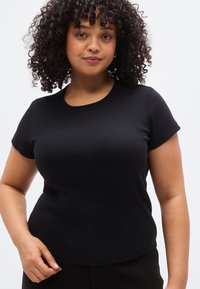 Μαύρο ριπ κοντομάνικο T-shirt με στρογγυλή λαιμόκοψη, με εφαρμοστή γραμμή και λεία υφή. Τονίζει τη σιλουέτα.