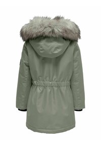 Žalias parka su dirbtiniu pūkų gobtuvu, reguliuojamu juosmeniu, elastinėmis rankogaliais ir lygiu išoriniu paviršiumi. Yra apvalus apmušalas ir atvira nugara.