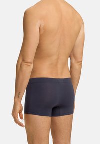 Námořnicky modré bavlněné boxerky s přiléhavým střihem, hladkou texturou a jemným logem na pásku. Viditelné švy na švech.