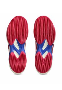 Sole di scarpe sportive rosse e blu con un motivo a zigzag, materiale in gomma solida e un accento di intersuola bianca a contrasto.
