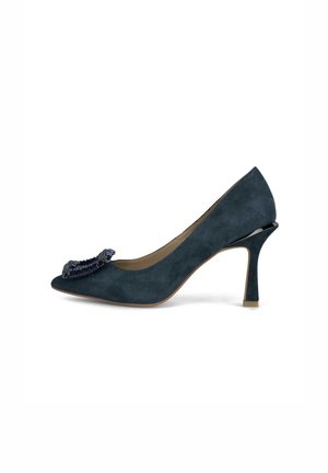 Pump in camoscio blu con punta affusolata e un fiocco decorativo. Caratterizzato da un tacco a stiletto e una texture liscia con un leggero lucido sulla suola.