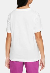 Camiseta blanca de algodón de manga corta, con un cuello redondo sencillo y una textura suave. Vista trasera que muestra un diseño liso, sin logotipos ni patrones.