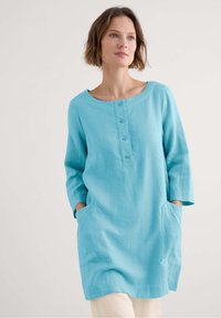 Turquoise linnen tuniek met een ronde halslijn, knoopsluiting, driekwart mouwen en zijzakken. Soepele textuur, casual ontwerp.