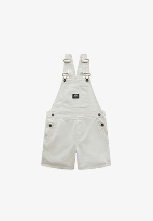 Petos cortos blancos con tirantes ajustables, bolsillo frontal en el pecho con parche del logo de Vans y detalles de botones en los laterales y tirantes.