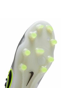 Sole delle scarpe da calcio con un design traslucido, tacchetti verde neon e logo swoosh nero. Finitura liscia con texture ondulata.