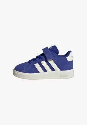 Scarpa Adidas blu con suola bianca, tre strisce bianche, lacci e una fascia in Velcro su sfondo bianco.