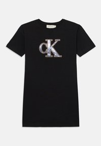 Black cotton t-shirt featuring a large, metallic silver and blue "CK" logo on the front. Short sleeves, crew neck design.