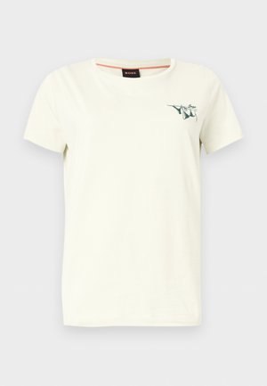 Μπεζ κοντομάνικη μπλούζα με στρογγυλή λαιμόκοψη, μικρό πράσινο σχέδιο και την επιγραφή «Boss» στο αριστερό στήθος, μονόχρωμο φόντο.