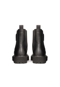 Botas de tobillo de cuero negro con paneles laterales elásticos, suela de goma gruesa y tiradores en la parte posterior, con acabados lisos y texturizados.