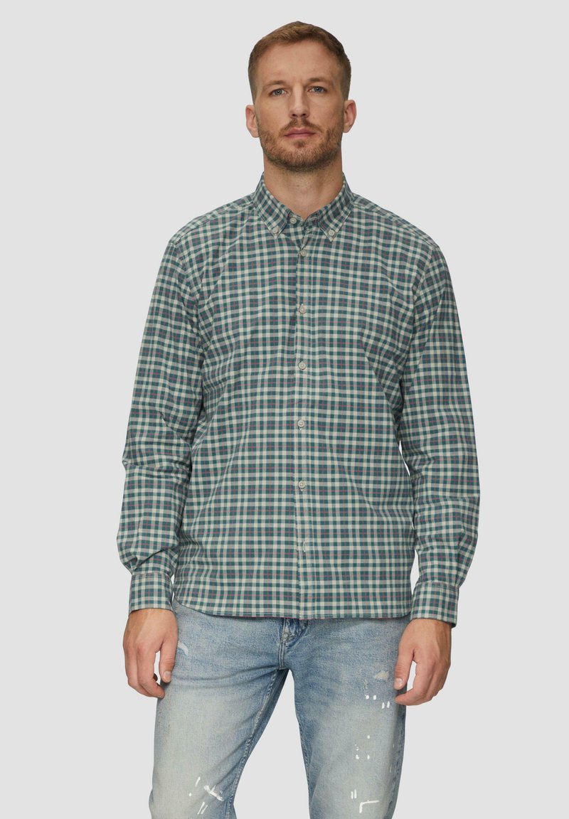 Overshirt in een groen en blauw geruit patroon, gemaakt van katoen met lange mouwen en een kraag. Draag met lichtblauwe versleten jeans.
