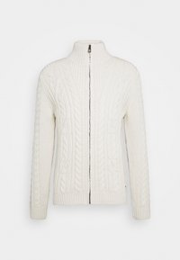 Krämfärgad stickad tröja med hög krage, med en hel dragkedja framtill och flätstickad mönster över kroppen och ärmarna.