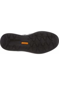 Semelle en caoutchouc noir avec motif de relief texturé et logo. Présente des rainures en zigzag pour une meilleure adhérence et stabilité. Durable et conçue pour la traction.