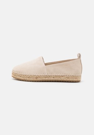 Beige instap-espadrille met geweven jutezool en rubberen buitenzool, voorzien van een laag achteraan trekkertje en subtiele zijbranding.