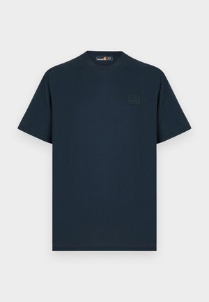T-shirt bleu marine à manches courtes et col rond avec un petit patch logo Timberland ton sur ton sur le côté gauche de la poitrine.