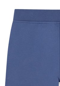 Gros plan sur une ceinture en tissu bleu avec des coutures visibles sur un matériau doux et extensible, probablement partie d'une tenue de sport ou décontractée.