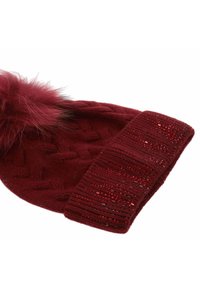 Cappello a maglia bordeaux con motivo a texture, caratterizzato da un pompon in pelliccia sintetica soffice sulla cima e da un risvolto a coste decorato.