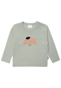 Langärmliges, mintgrünes Hemd aus weichem Baumwollstoff. Mit einem Croissant-Graphic mit einem lächelnden Gesicht und schwarzem Barett sowie einem Etikett am Kragen.