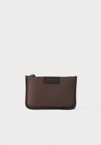 Petite pochette rectangulaire en tissu marron avec bordure noire et fermeture éclair sur le dessus, affichant un écusson de logo noir au centre.