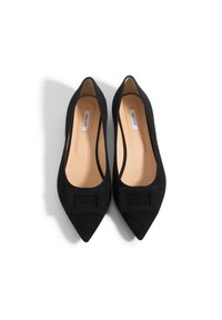 Czarne zamszowe czółenka na szpilce z ostrym noskiem i płaską kokardką z przodu oraz gładką beżową wkładką. Prosty design z klasyczną sylwetką.
