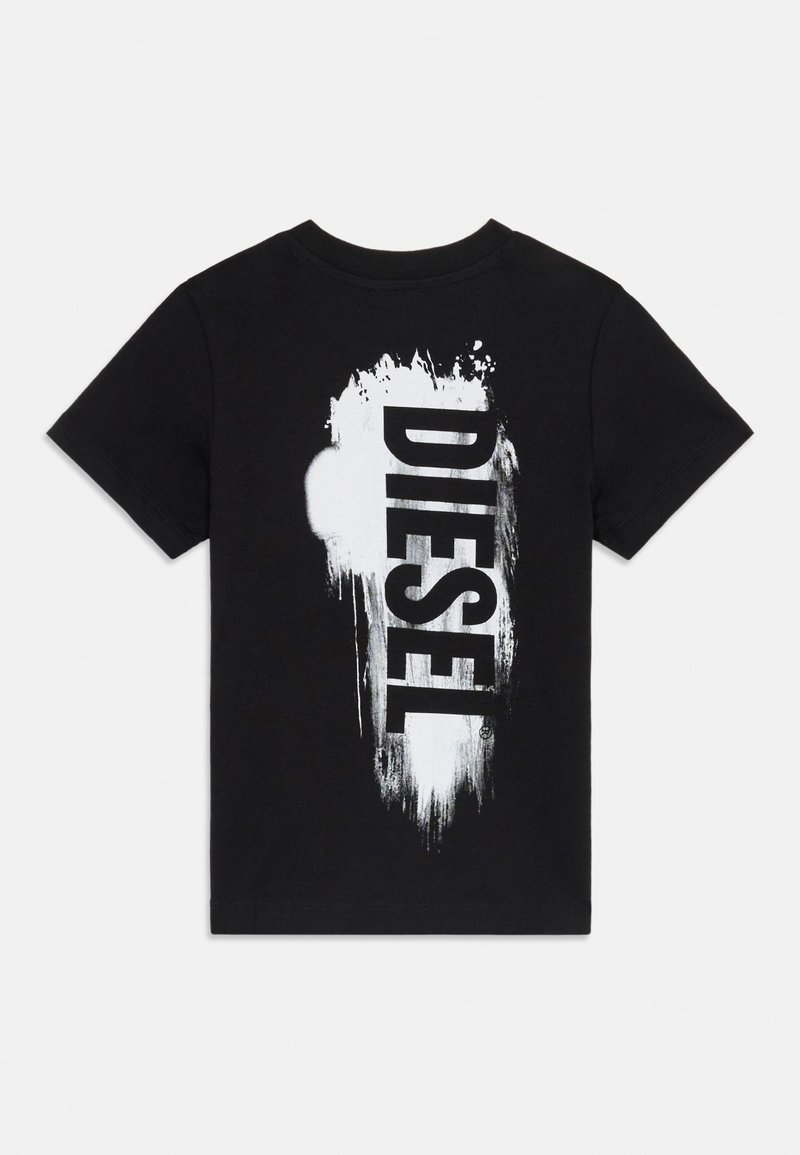 T-shirt in cotone nero con una grande stampa grafica bianca della parola "DIESEL" con dettagli di vernice schizzata. Design a maniche corte e colletto rotondo.
