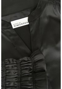Schwarzes Satin-Kleid mit V-Ausschnitt, gerafftem Rüschendetail an der Taille und einem Etikett mit der Aufschrift "KAREN BY SIMONSEN." Glatte Textur.
