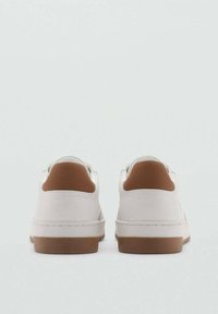 Adidași albi cu un material superior neted, având un tab brun la călcâi și o talpă din cauciuc. Design minimalist, linii curate și fără logo-uri vizibile.