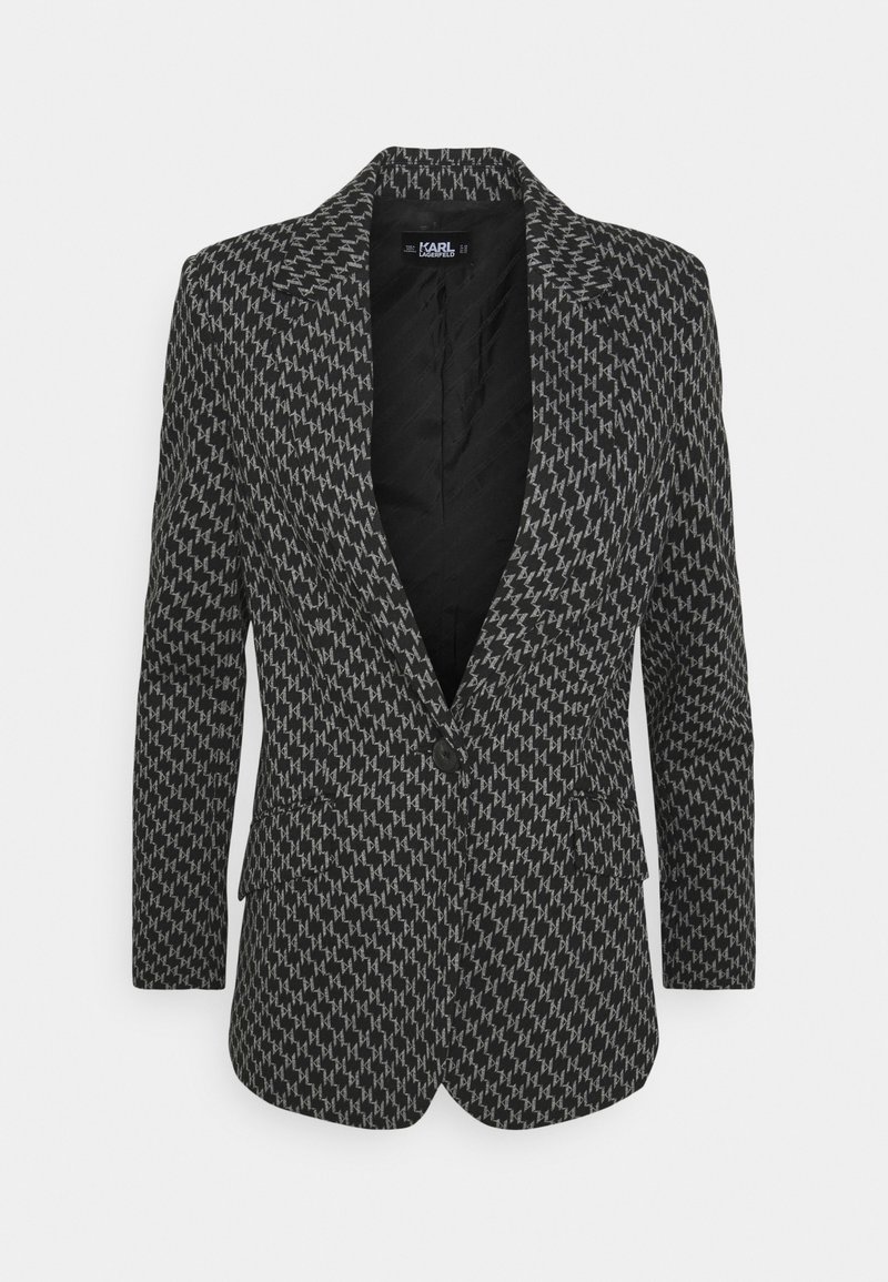 Svart och grå houndstooth-mönstrad blazer med en skarp krage, enkel knappstängning och två framfickor. Slät tygtextur.