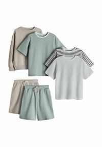 Sudadera beige, camisa de manga corta verde, camisa a rayas, camisa blanca de manga corta, pantalones cortos beige y pantalones cortos verdes dispuestos sobre fondo blanco.