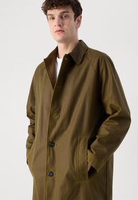 Olive green coat made of durable fabric, featuring a wide collar, button closure, and side pockets. Smooth texture with minimal detailing.
