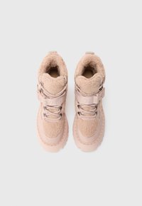 Para różowych wysokich botków z grubymi gumowymi podeszwami i miękkim, wełnianym wyściełaniem, zapinanych na sznurowadła i szerokie, oznakowane paski z przodu.