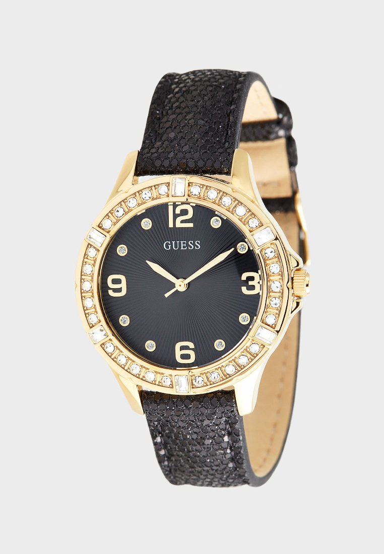 Montre dorée avec un bracelet noir texturé, un cadran noir, des accents en forme de diamant et des chiffres en gras aux positions 3, 6, 9 et 12 heures.