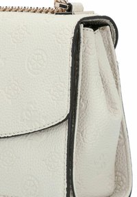 Borsa a tracolla in pelle bianca con texture, caratterizzata da motivi circolari embossati e un dettaglio della catena argentata lungo il bordo superiore.