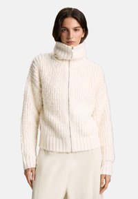 Biely sveter na zips s vysokým golierom, textúrovaná, chlpatá tkanina, rebrované manžety a lem, s jemným reliéfnym vzorom.