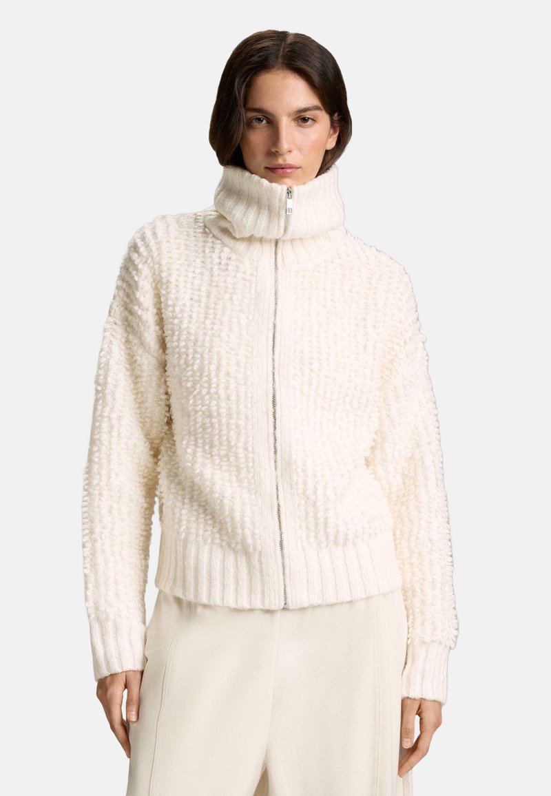 Biely sveter na zips s vysokým golierom, textúrovaná, chlpatá tkanina, rebrované manžety a lem, s jemným reliéfnym vzorom.