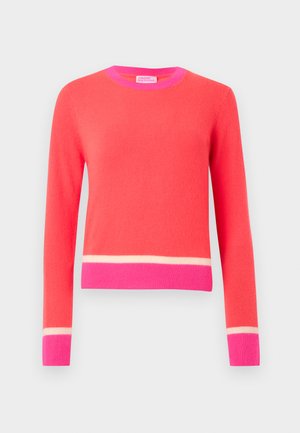 Long-sleeve coral sweater with bright pink collar, cuffs, and waistband, featuring a thin cream stripe above cuffs and waistband.