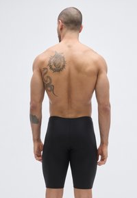 Czarne dopasowane szorty wykonane z elastycznego materiału, zaprojektowane o gładkiej fakturze. Posiadają wysoki pas i brak widocznych szwów.