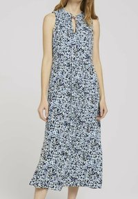 Kukallinen mekko, jossa on istuva yläosa ja levenevä hame, avaimenreikään muotoiltu kaula-aukko ja olkaimeton malli. Taustaväri on tummansininen.