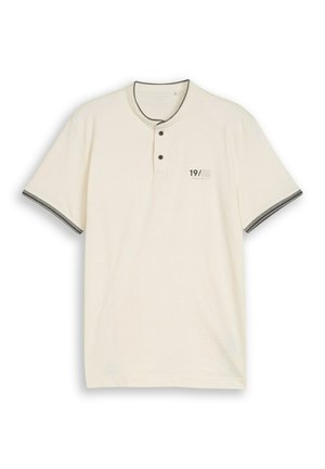Kremowa koszulka typu henley z krótkim rękawem, dwoma guzikami, czarnym obszyciem kołnierza i rękawów oraz napisem "19/62" na lewej piersi.