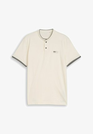 Kremowa koszulka typu henley z krótkim rękawem, dwoma guzikami, czarnym obszyciem kołnierza i rękawów oraz napisem "19/62" na lewej piersi.