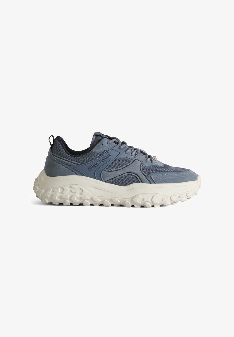 Baskets bleues et grises avec une semelle épaisse blanche texturée et un design à lacets, avec des panneaux en mesh et en suède et une languette au talon.