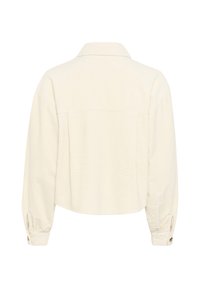 Kropēts garām piedurknēm tops off-white krāsā ar teksturētu audumu, apkakli, aizmugurējo daļu ar šuvēm un pogām pie piedurkņu galiem. Iezīmēts ar brīvu piegriezumu.