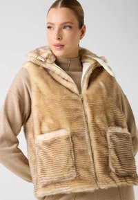 Nepbontussenjas met ritssluiting in lichtbeige met een gestreept textuurpatroon. Voorzien van een capuchon, twee voorzakken en een zachte binnenvoering.