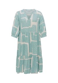 Vaaleansininen mekko, jossa on geometrinen valkoinen kuvio, v-kaula-aukko, kolme neljänneksen hihaa ja kerroksittain laskeutuva hame. Valmistettu pehmeästä kankaasta.