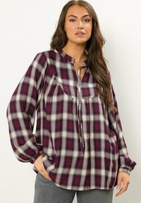 Langschedige geruite blouse in paars en wit, met een sleufhalslijn en gatherende manchetten, gemaakt van zachte stof met een ontspannen pasvorm.